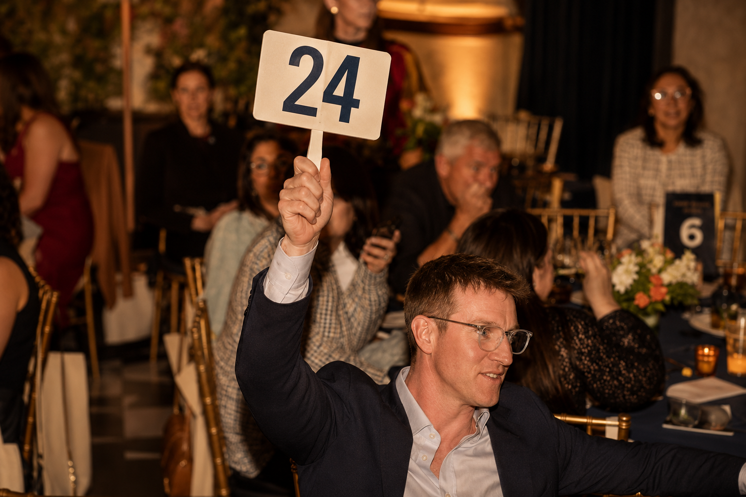 Bidder raising paddle at a benefit auction